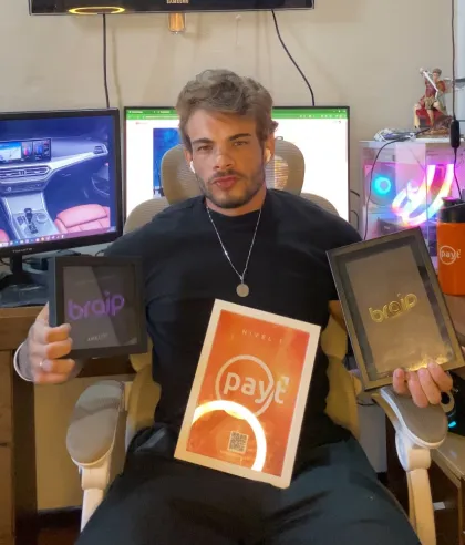 Pedro Lucas, fundador da Impulso Digital, com placas de premiação da Braip e da Payt